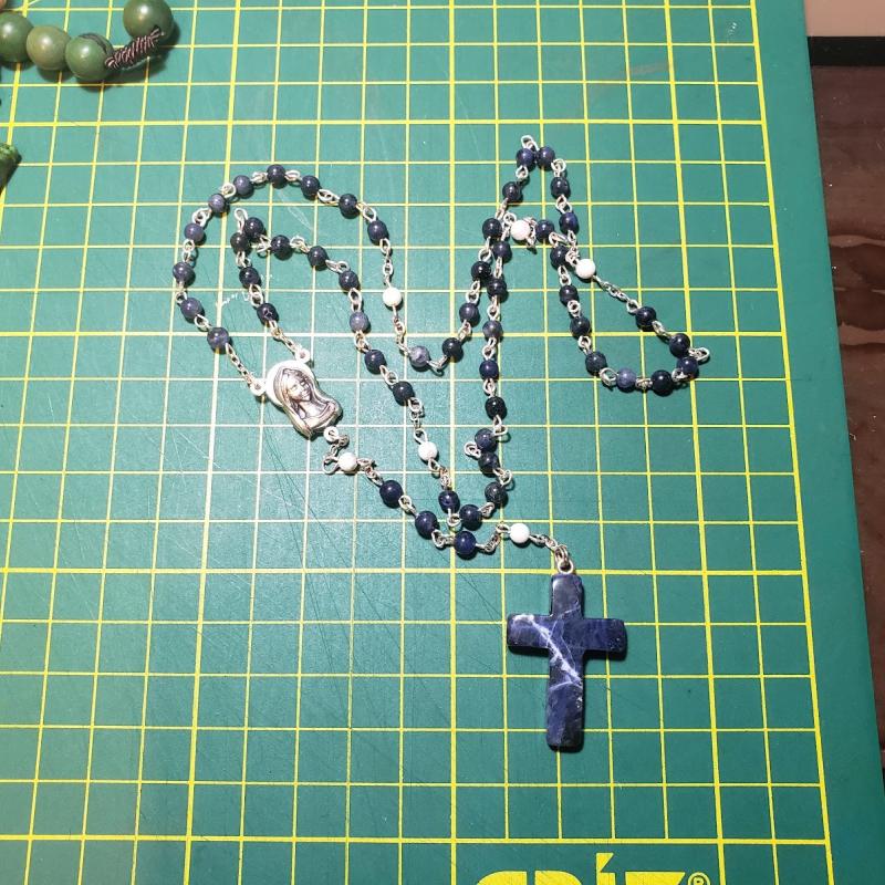 Rosario con cuentas de piedra mineral y cruz de metal plateado